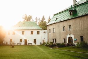a large white building with a green roof and a yard at Lesny Dwór w Górach Sowich in Wolibórz