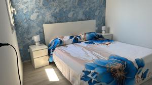 a bedroom with a bed with a blue wall at L' Occhio del mare in Giardini Naxos +40 photos