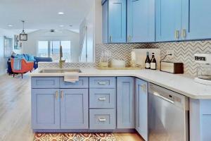 a kitchen with blue cabinets and a counter top at Charming 3 bedroom Beach Front Cottage in Milford