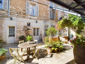 a patio with a table and chairs and plants at Repos à Ribérac B&B in Ribérac