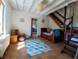 a room with a staircase and a bed and a rug at Gites de la Bénardière in Vallières-les-Grandes