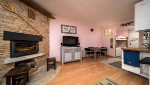 a living room with a fireplace and a tv at AURIAC - A01- STUDIO Cabine 4 pers in La Foux