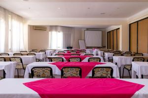 a room with rows of tables and chairs with pink table cloth at Royal Court Hotel in Mombasa