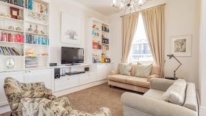a living room with two couches and a tv at Six Selbourne in Cape Town