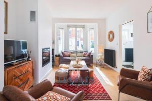 a living room with a couch and a tv at La Bargnia : Maison Touquettoise in Le Touquet-Paris-Plage