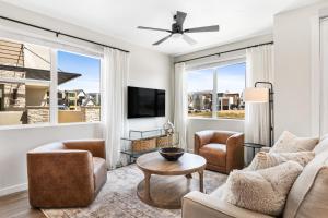 een woonkamer met een bank, stoelen en een tv bij Paradise Cove condo in Atkinville