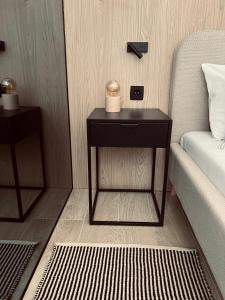 a side table with two candles on it next to a bed at Apartments Mrdak in Bar