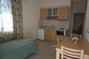 a small kitchen with a table and a dining room at Anna's Studios in Kamena Vourla