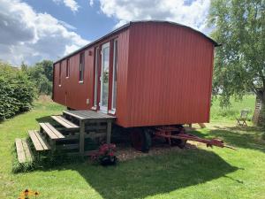 JesbergTiny House im Grünen的坐在木板上的红色小房子