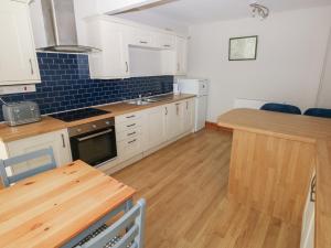 a kitchen with white cabinets and a wooden table at The Old Post Office in Haverfordwest