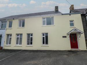 a white house with a red door at The Old Post Office in Haverfordwest