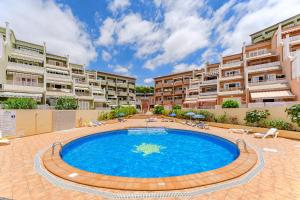 阿德耶Apartamentos ORLANDO en Costa Adeje的庭院中央的游泳池,设有公寓楼
