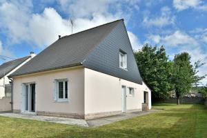 a white house with a black roof at Au Ty Mitine - A 4min en voiture de la plage in Saint-Cast-le-Guildo
