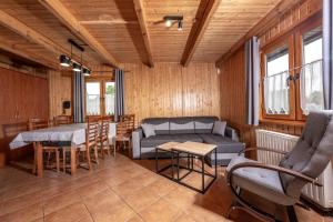 a living room with a couch and a table and chairs at Ośrodek Rekreacyjny Aga in Gąski