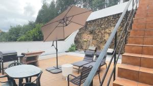 a patio with a table and chairs and an umbrella at Villa for Short Term Medium Long Stay in Trofa