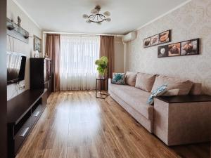 a living room with a couch and a television at Sweet Home on Shevchenko street in Vinnytsya