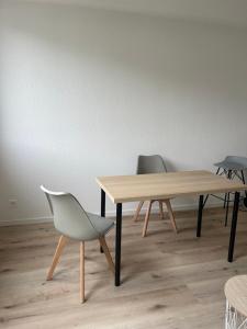 a wooden table and two chairs in a room at Appartement Sisi in Geneva