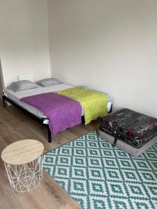 a bedroom with a bed and a table and a rug at Appartement Sisi in Geneva