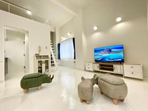 two stuffed animals in a living room with a flat screen tv at 彩光堂Village KAME101&202 in Tokyo