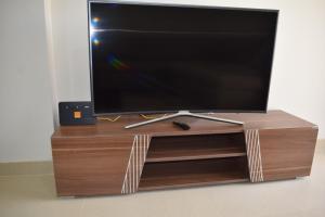 TV de pantalla plana en un centro de entretenimiento de madera en Whispering Waters Two Bedroom with a Garden Azha, en Ain Sokhna