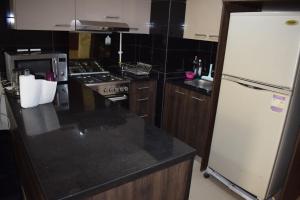 Una cocina con un refrigerador blanco y una estufa. en Whispering Waters Two Bedroom with a Garden Azha, en Ain Sokhna 22 fotos más