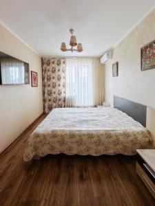 Un dormitorio con una cama grande y una ventana. en Family apartment on Shevchenko street, en Vínnytsia 18 fotos más