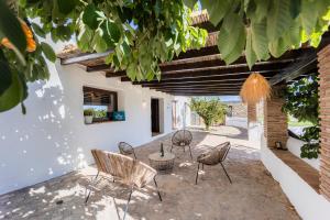 un patio con sillas y una mesa en un edificio en RentitSpain Complejo Rural Los Fandangos Lujo y Confort, en Almuñécar