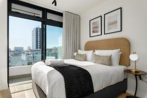 a bedroom with a large bed and a large window at The Sage Luxury Apartment Hotel in Cape Town
