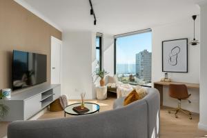 Una sala de estar con un sofá y un televisor. en The Sage Luxury Apartment Hotel, en Ciudad del Cabo
