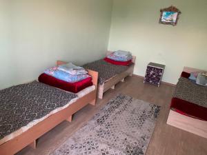 a room with three beds and a rug at Гостевой дом in Cholpon-Ata +15 photos