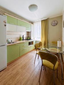 a kitchen with green cabinets and a table and chairs at Sweet Home on Shevchenko street in Vinnytsya +20 photos