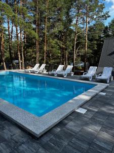 a swimming pool with lounge chairs and a swimming pool at Domki Sosnówka in Majdan Sopocki