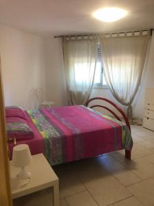 a bedroom with a bed and a table and a window at Villa Jobè in Polignano a Mare