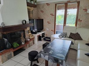 a living room with a couch and a fireplace at Jolie maison avec piscine in Labastide-Saint-Georges