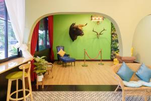 a room with a green wall with a cow head on it at SriRungRueng Place in Kanchanaburi