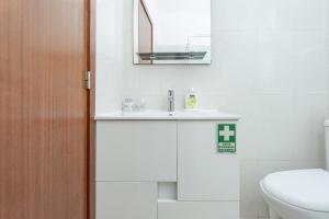 a bathroom with a sink and a toilet and a mirror at Alojamento Local Trigal in Funchal +20 photos
