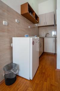 a kitchen with a white refrigerator and a wooden floor at Mrzenci Apartments in Gevgelija +15 photos