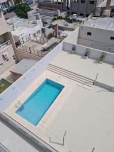 eine Draufsicht auf einen Swimmingpool auf dem Dach eines Gebäudes in der Unterkunft AC Suites in Puerto Madryn + 5 Fotos