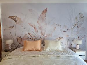 玛德琳港AC Suites的卧室里有一张床，墙上有一幅花卉壁画