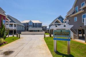 un panneau pour une école et un studio devant les maisons dans l'établissement NH387D Cape Lookout Cottage, à Nags Head
