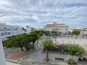 einen Park mit Bäumen und Bänken in einer Stadt in der Unterkunft Apartamento Malandar in Sanlúcar de Barrameda