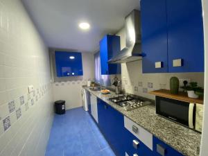 eine blau-weiße Küche mit blauen Schränken in der Unterkunft Apartamento Malandar in Sanlúcar de Barrameda