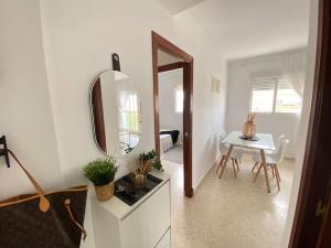 ein weißes Zimmer mit einem Tisch und einem Spiegel in der Unterkunft Apartamento Malandar in Sanlúcar de Barrameda + 12 Fotos