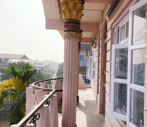 巴拉特布尔Ojas Home Bharatpur - 奥贾斯之家巴拉特普尔的带有阳台的建筑物侧面的柱子