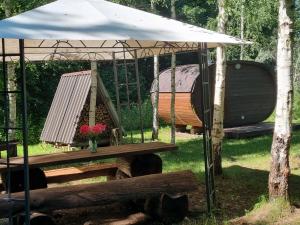 a hammock and a swing under an umbrella at Privaatne puhkemajake koos saunamajaga in Metsakivi +7 photos