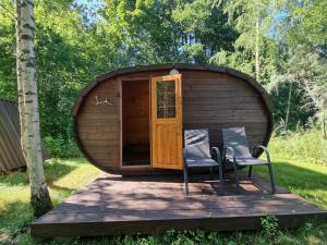 a large wooden shed with two chairs on a deck at Privaatne puhkemajake koos saunamajaga in Metsakivi