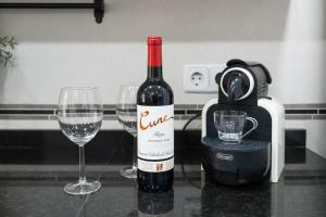 a bottle of wine sitting next to two wine glasses at Elefantes in Rivas-Vaciamadrid +5 photos