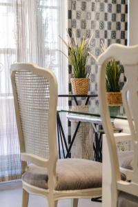 a dining room with two chairs and a table with plants at Elefantes in Rivas-Vaciamadrid