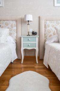 a bedroom with two beds and a table with a lamp at Elefantes in Rivas-Vaciamadrid