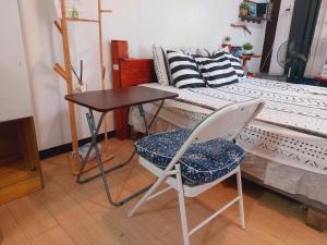 a table and a chair next to a bed at The Lakehouse Studio Tagaytay in Tagaytay